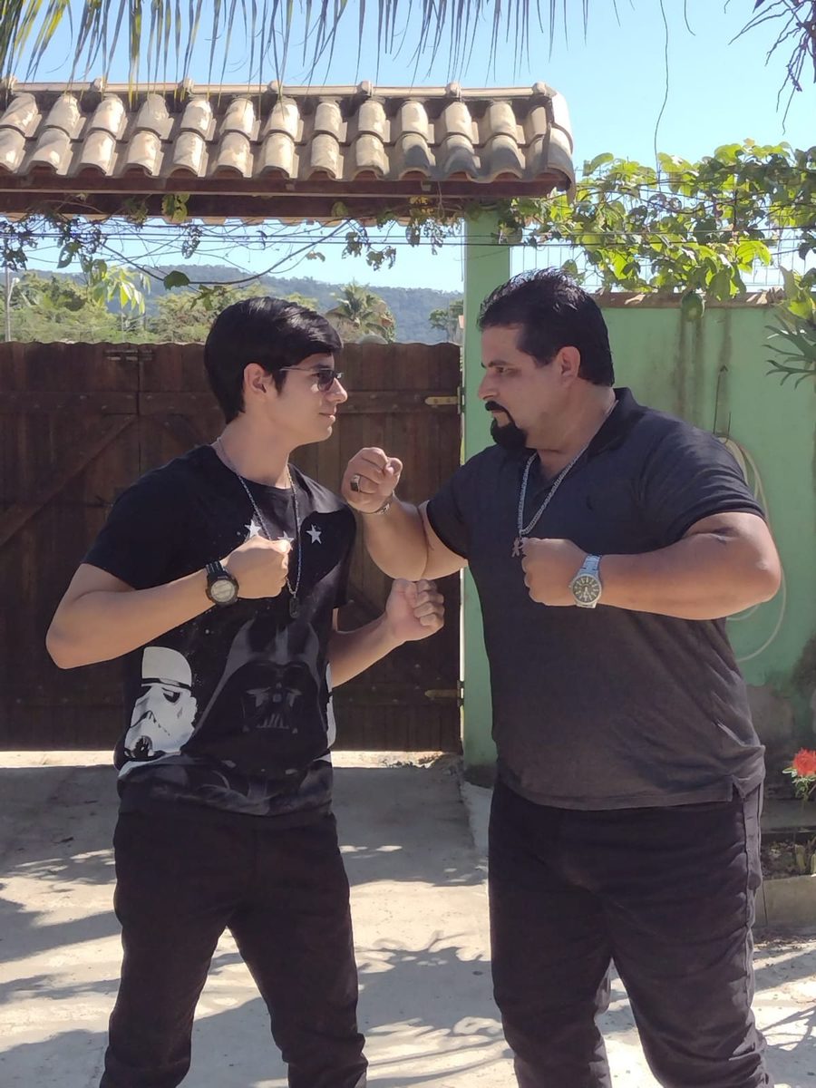 Daniel adulto e Maurício de frente um para o outro, fazendo pose de força.
